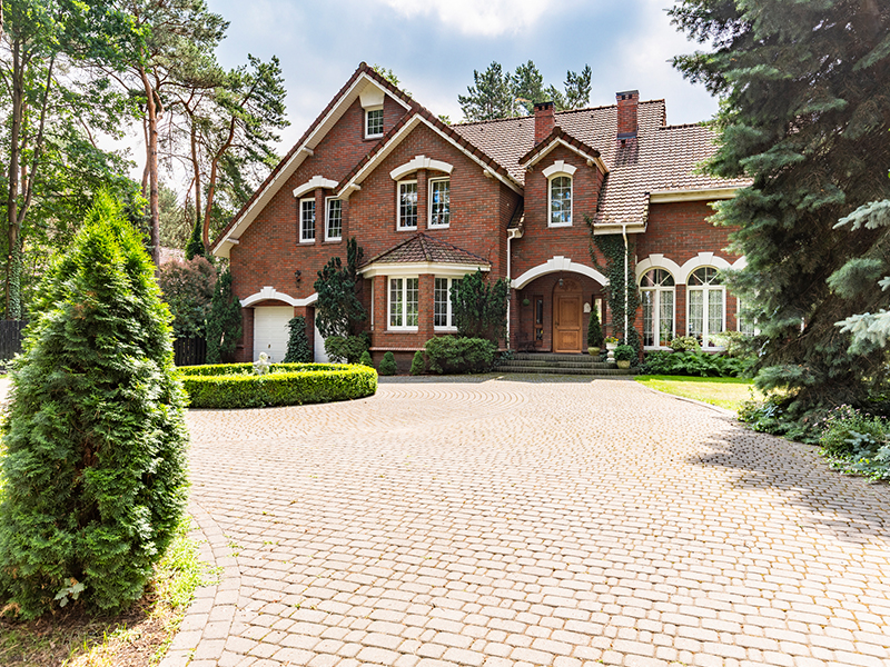 driveway in front of red brick mansion